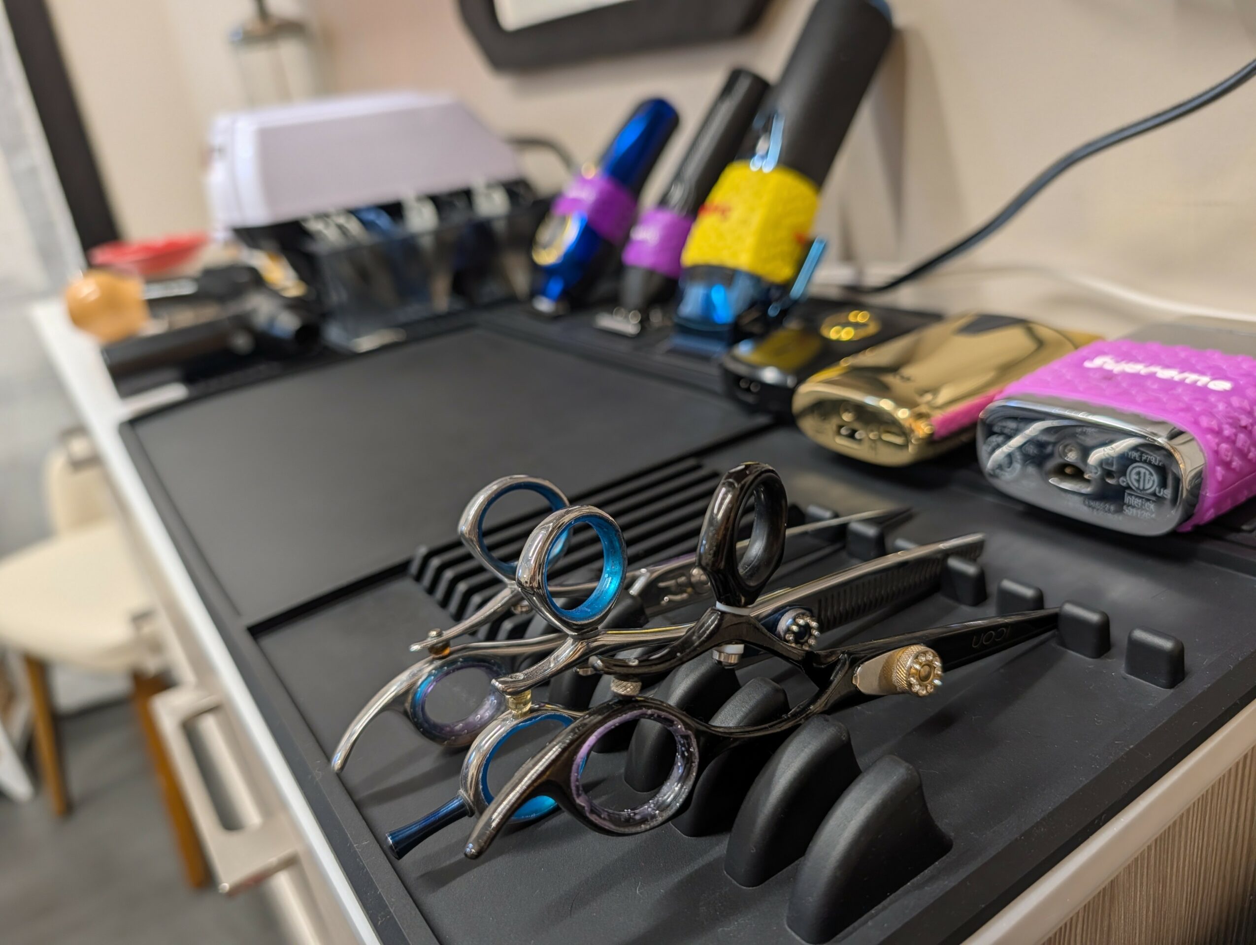Dental tools and equipment on a black tray, with dental curing lights and a pink battery pack visible.