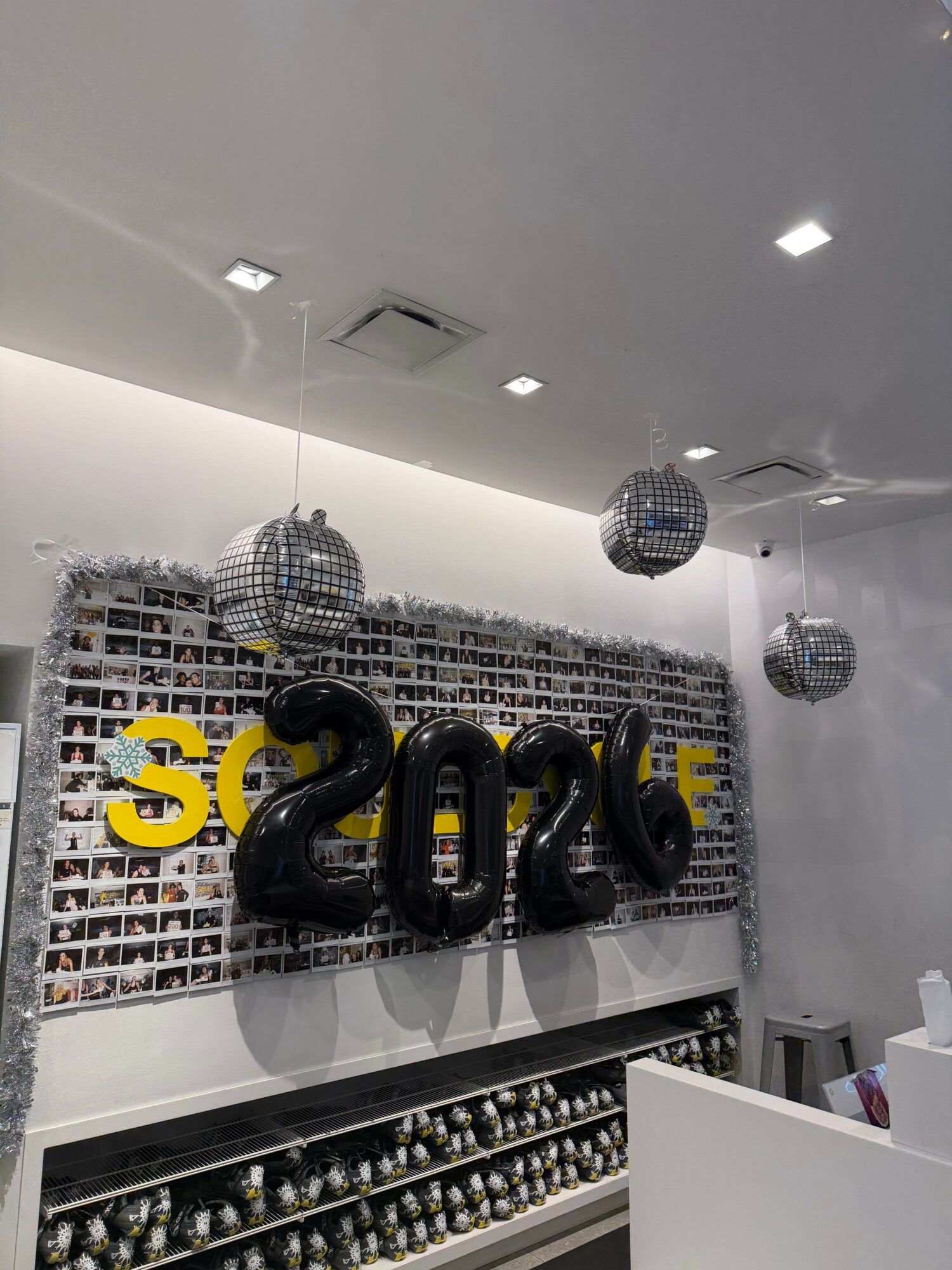 Decorative interior with hanging spherical lights, a brick wall, and large black and yellow numbers on the wall.