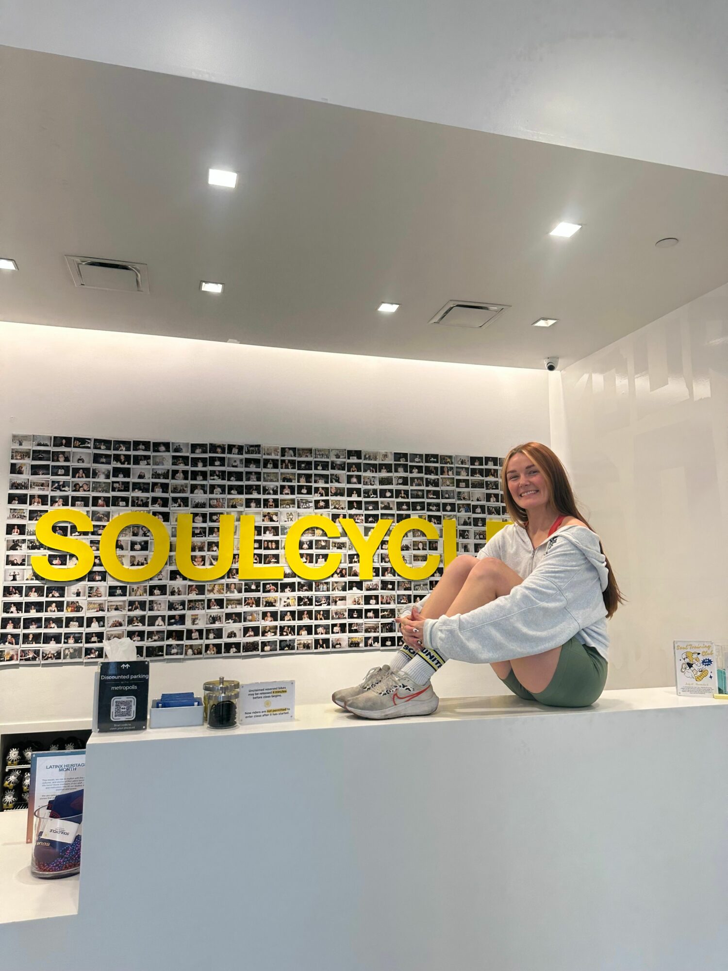 Woman crouching in front of a sign that reads 'SOUVENIRS' in a store interior.