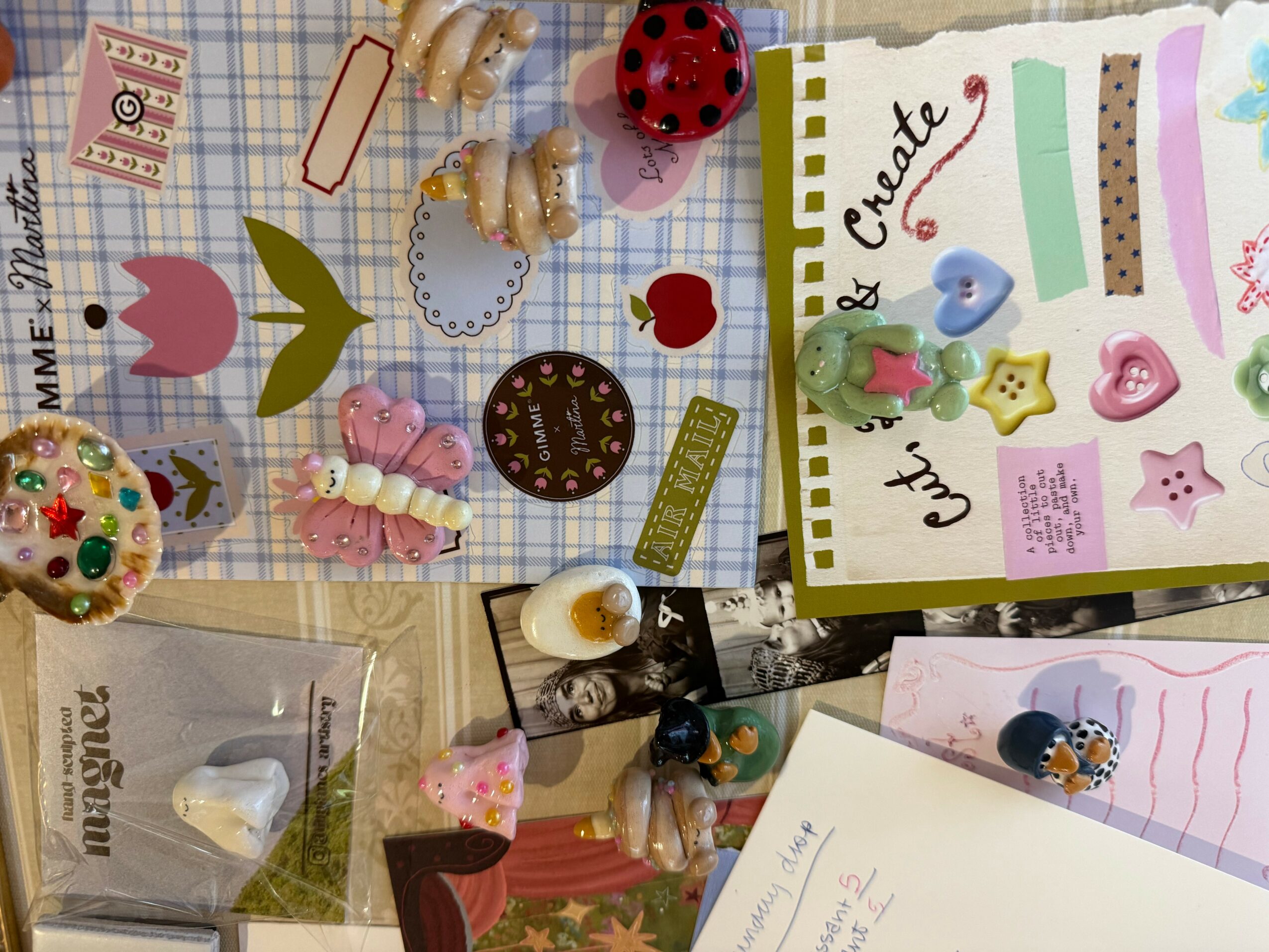 Colorful craft supplies, including buttons, paper, and decorations, arranged on a surface with a create and craft theme.