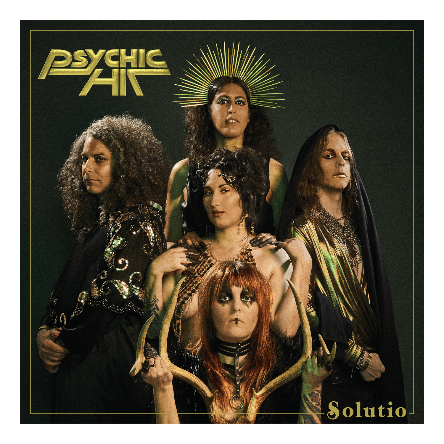 Group of five women with mystical and dramatic appearance, some with headpieces and elaborate costumes, against a dark background.