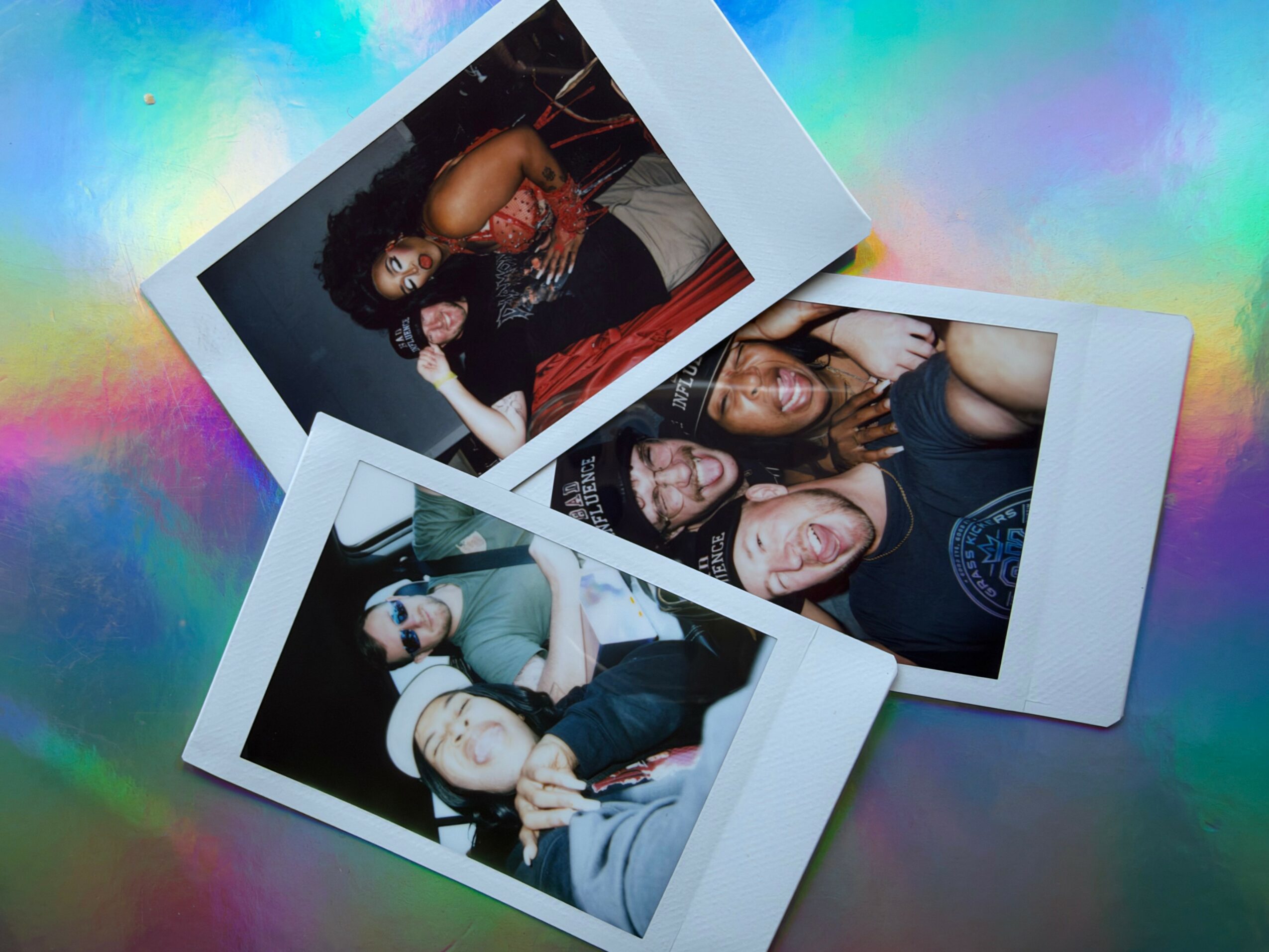 Three Polaroid photos of people smiling and posing, on a colorful, iridescent background.
