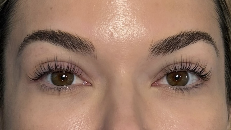 Close-up of a person's eyes and eyebrows with clear skin and well-groomed eyebrows.