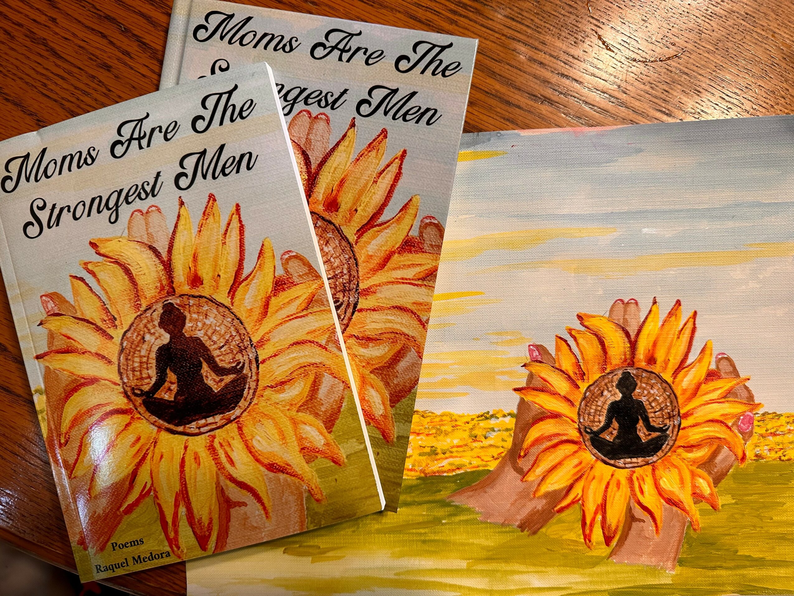 Two booklets with sunflower illustrations and a person sitting inside the sunflower, placed on a wooden surface.