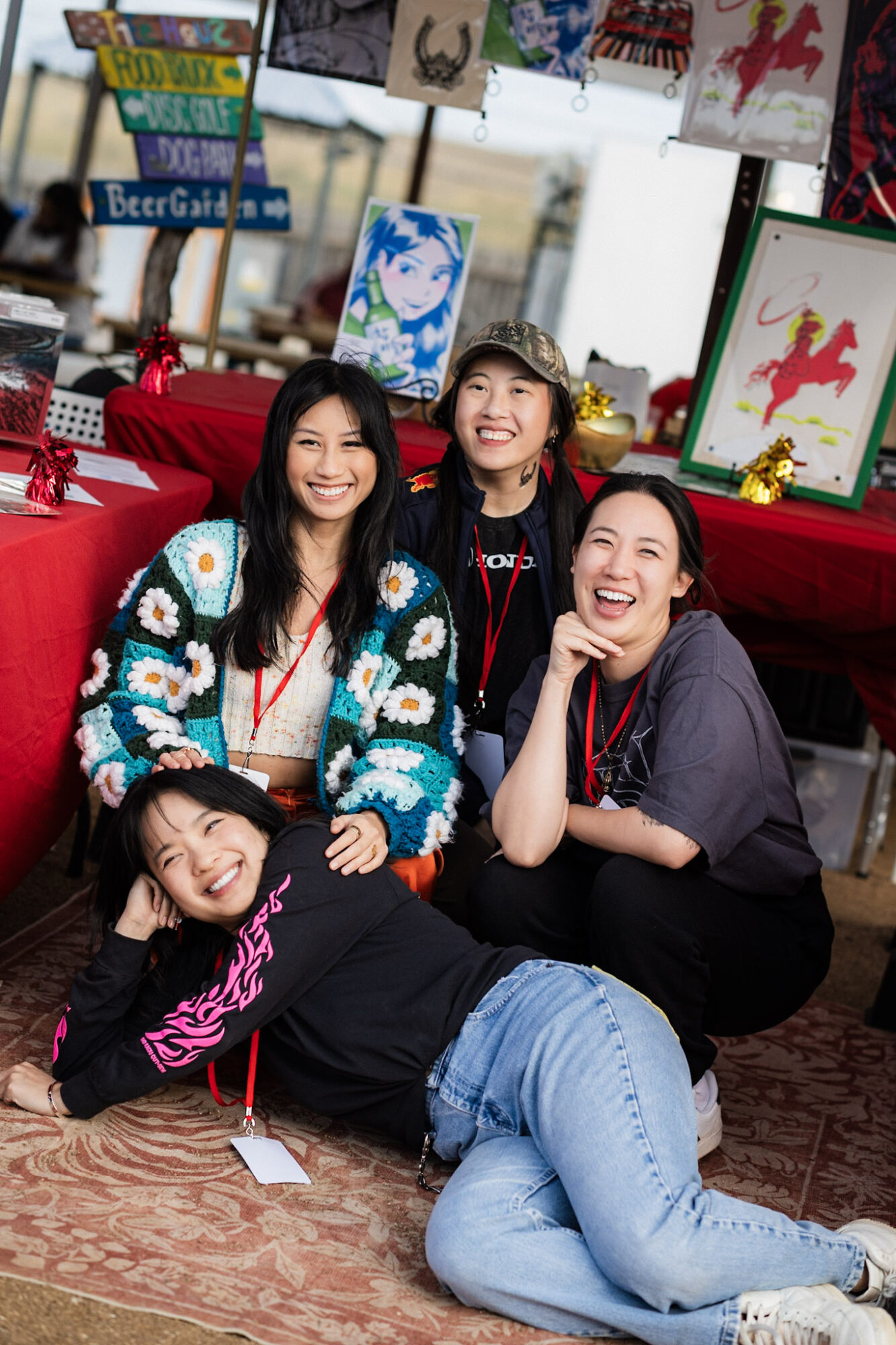 Four people pose together in a colorful room with red seating and framed artwork.