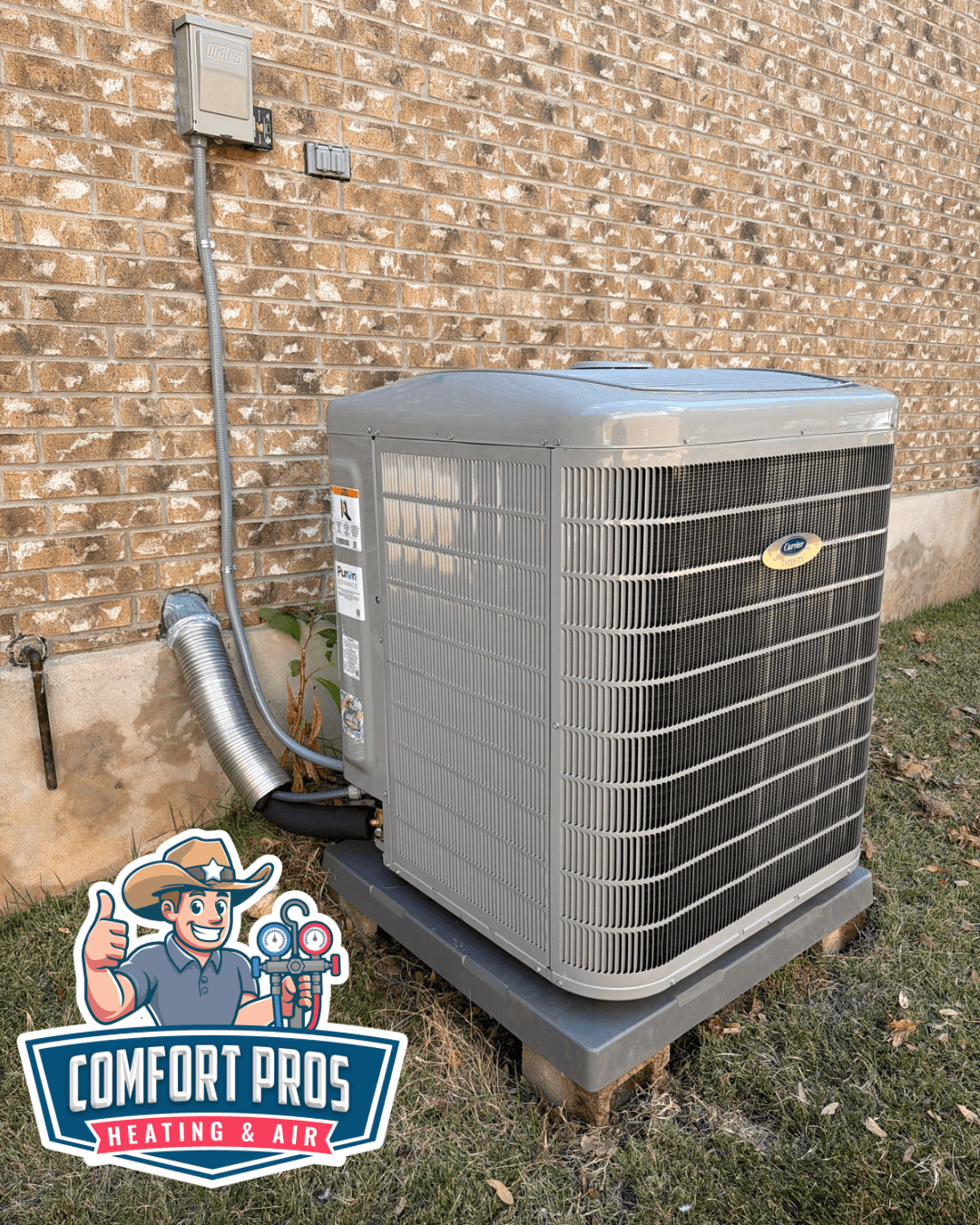 Outdoor air conditioning unit beside a brick wall, with a Comfort Pros Heating & Air logo in the lower left.