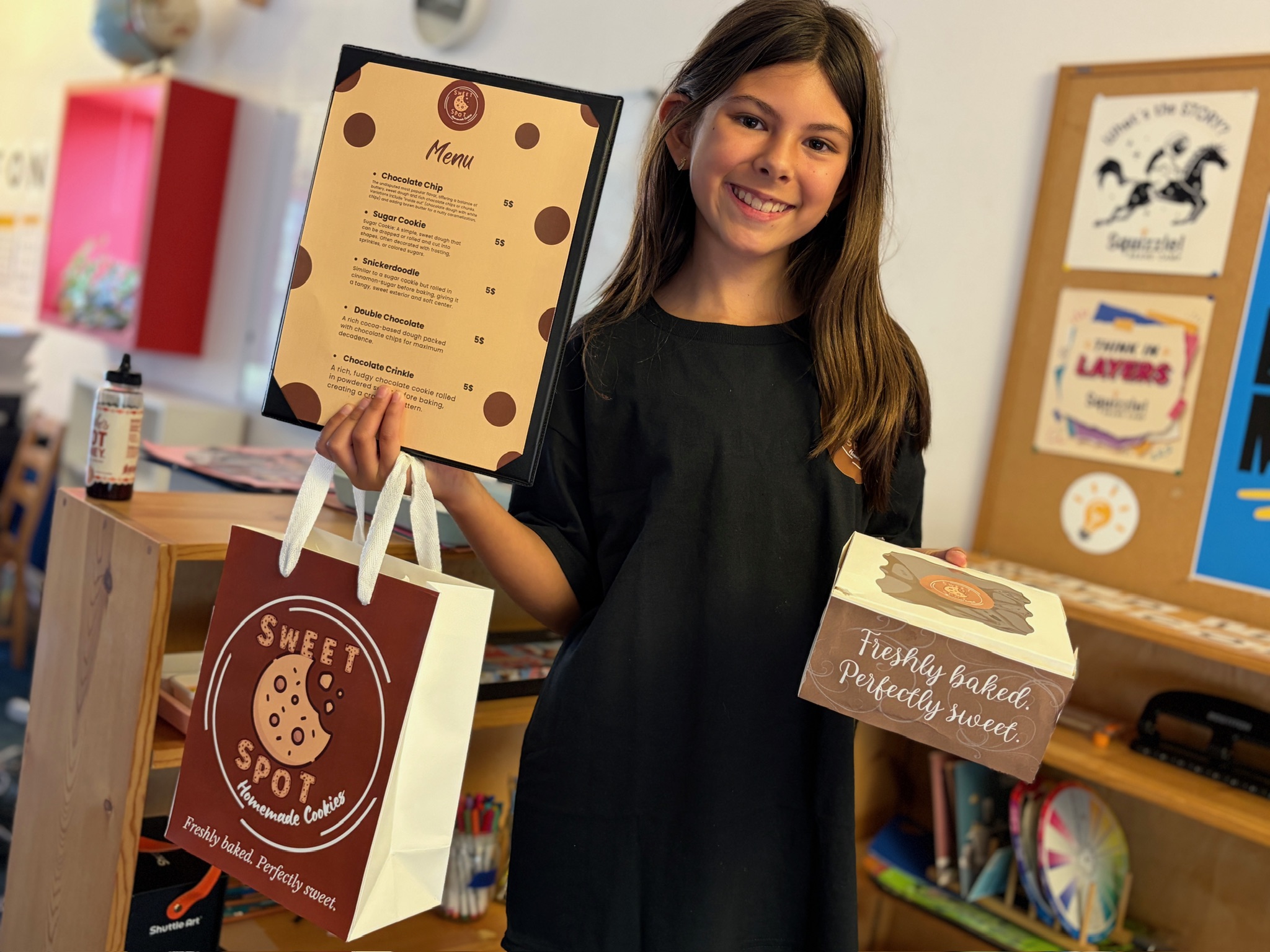 A person holds a framed certificate and a shopping bag beside a display of baked goods.