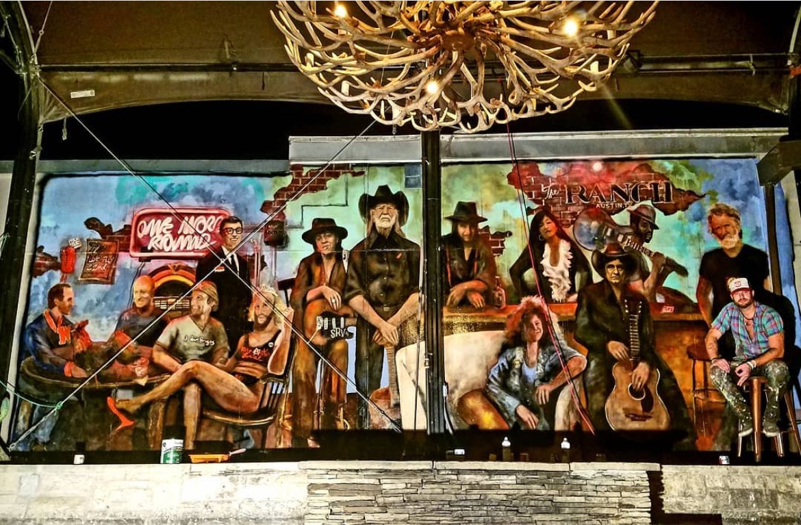 A large colorful mural depicts musicians playing instruments beneath a chandelier.