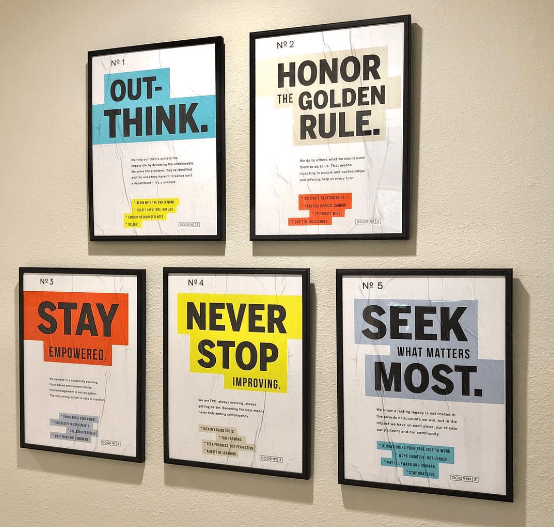 Five framed motivational posters on a wall, with bold phrases including “Think,” “Honor the Golden Rule,” “Stay,” “Never Stop,” and “Seek.”
